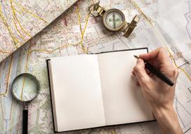 Somone taking notes with a map in background