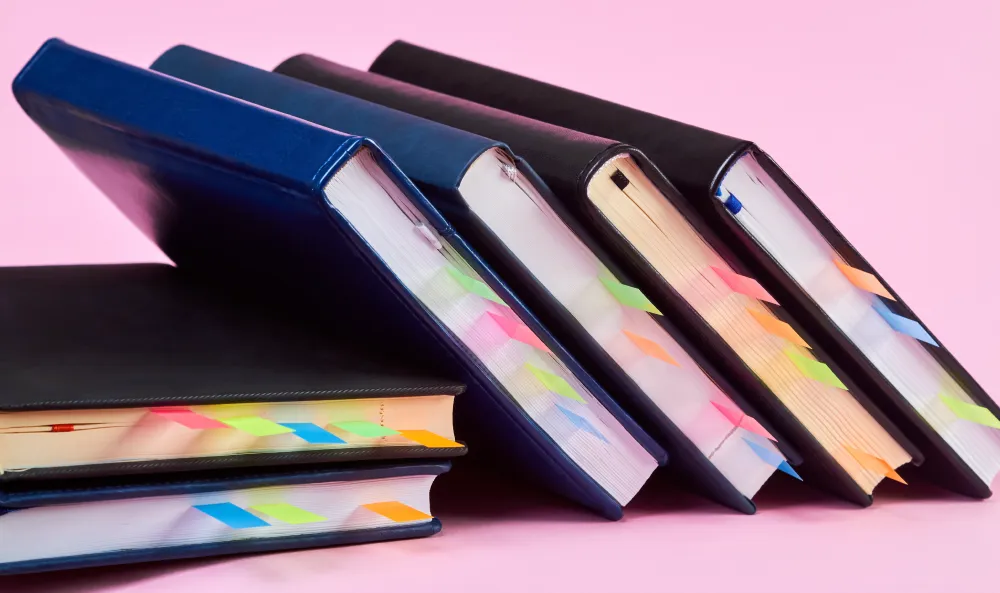 a messy pile of books with tabs in them